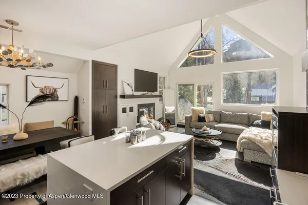 a living room with furniture a flat screen tv and a table