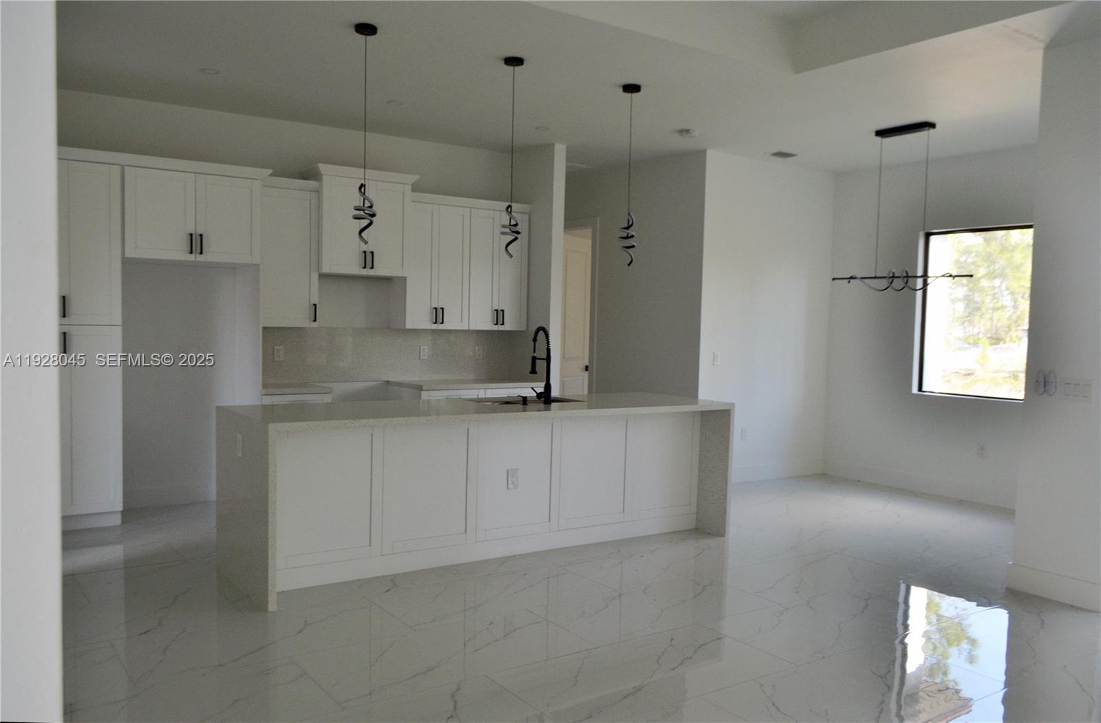 1116 Eight Street Lehigh Acres, FL 33972 - Photo 7 of 20 a large white kitchen with granite countertop a white stove top oven a sink and white cabinets