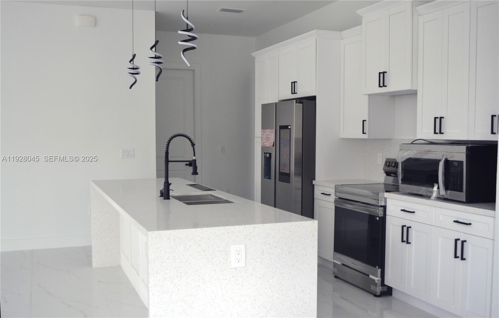 1116 Eight Street Lehigh Acres, FL 33972 - Photo 9 of 20 a kitchen with stainless steel appliances kitchen island a sink stove and refrigerator