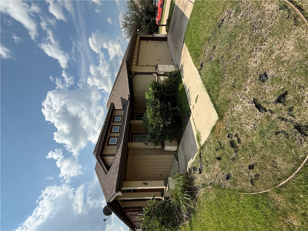 2208 Rindle Court Brenham, TX 77833 - Photo 21 of 22 a front view of a house with a yard and potted plants