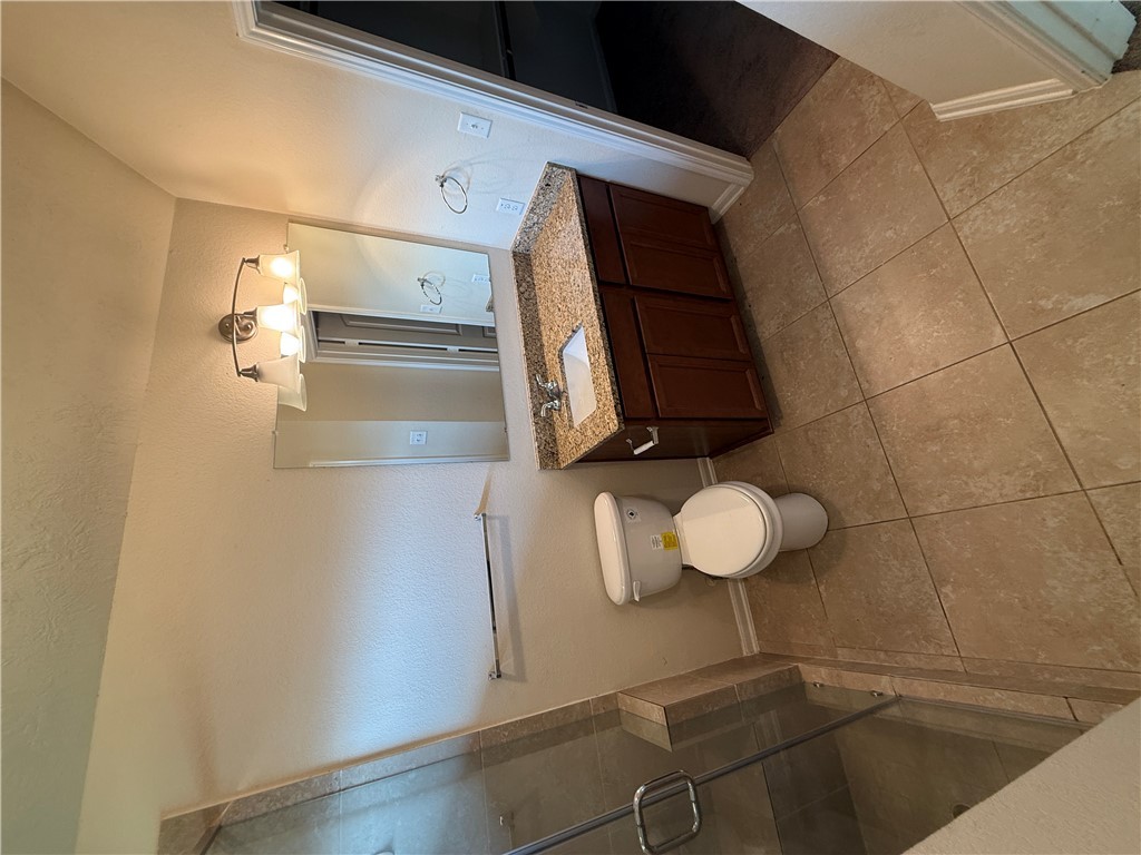 2208 Rindle Court Brenham, TX 77833 - Photo 6 of 22 a bathroom with a toilet sink and mirror