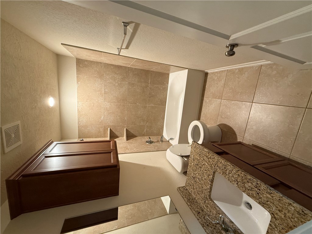 2208 Rindle Court Brenham, TX 77833 - Photo 7 of 22 a bathroom with a granite countertop sink toilet and shower