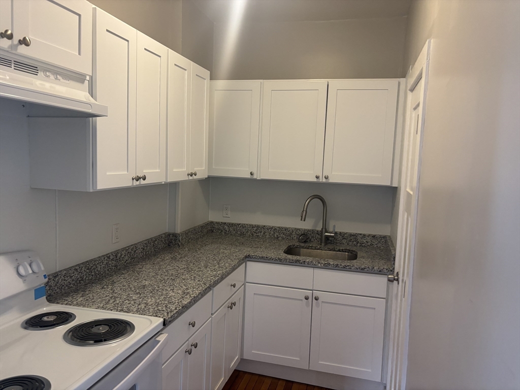 771 Rock Street Fall River, MA 02720 - Photo 26 of 31 a kitchen with granite countertop white cabinets and white appliances