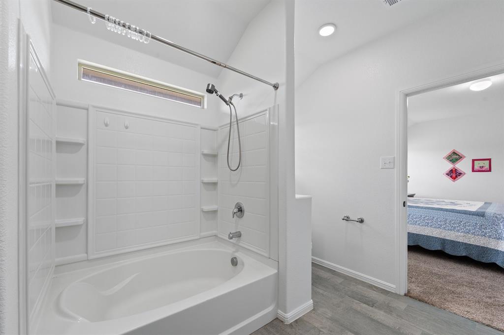 4600 Fringetree Way Crowley, TX 76036 - Photo 23 of 40 Bathroom featuring a white tub-shower combination with integrated shelving, a chrome showerhead with a handheld sprayer, and a transom window