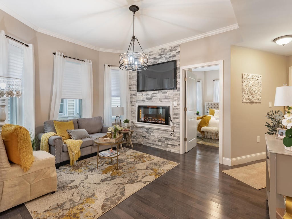 a living room with furniture a fireplace and a chandelier