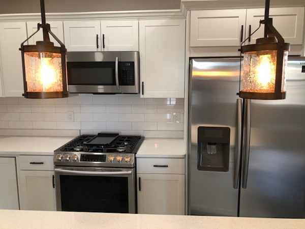 131 Congress Avenue, Unit 2 Chelsea, MA 02150 - Photo 12 of 30 a kitchen with stainless steel appliances a stove a microwave and a sink