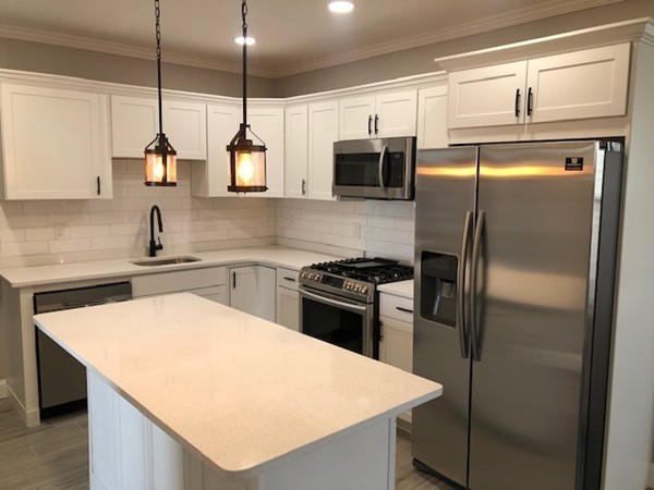 131 Congress Avenue, Unit 2 Chelsea, MA 02150 - Photo 8 of 30 a kitchen with stainless steel appliances granite countertop a sink a stove a refrigerator a washer and dryer