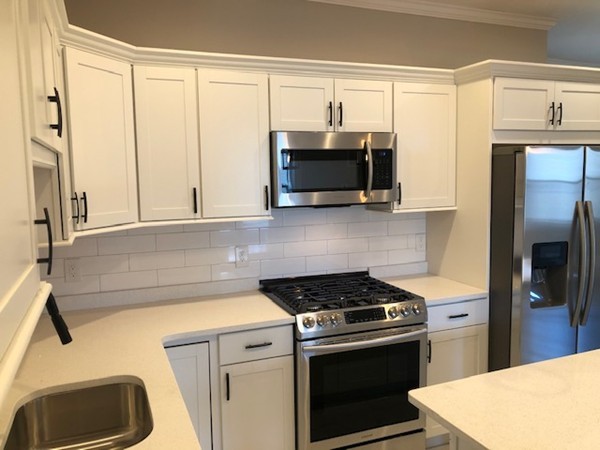 131 Congress Avenue, Unit 2 Chelsea, MA 02150 - Photo 9 of 30 a kitchen with stainless steel appliances a stove a microwave and a refrigerator