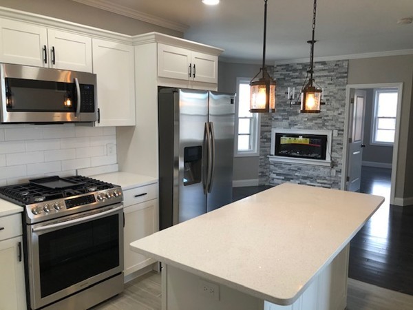 131 Congress Avenue, Unit 2 Chelsea, MA 02150 - Photo 10 of 30 a kitchen with stainless steel appliances kitchen island granite countertop a stove a refrigerator and a microwave