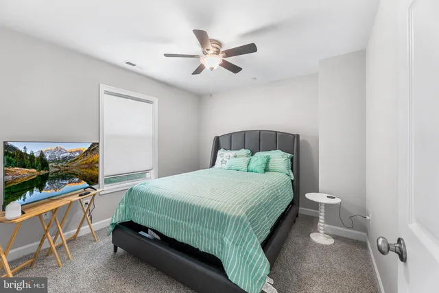 a bedroom with a bed and a flat tv screen on the dresser