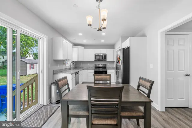 a kitchen with kitchen island a appliances dining table and chairs
