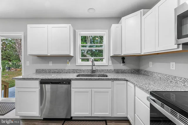 a kitchen with granite countertop wooden cabinets and a sink
