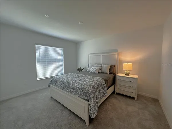 a bedroom with a bed and a lamp