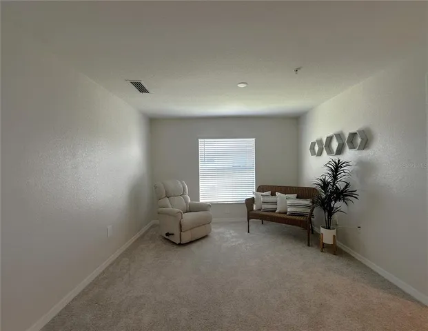 a living room with furniture and a floor to ceiling window