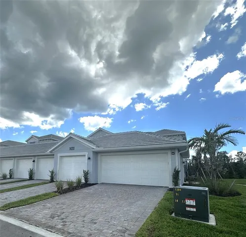 a front view of a house with garden and trees