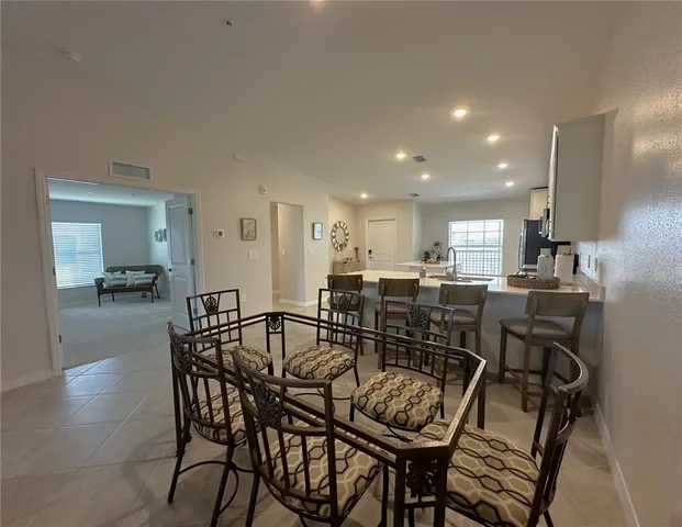 a kitchen with a dining table chairs and white cabinets