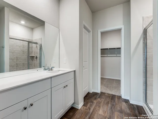 a en suite bathroom with a sink mirror and shower