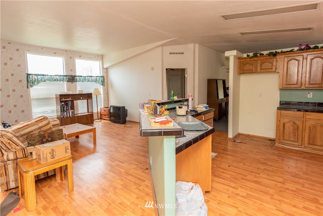 168 Katula Road Chehalis, WA 98532 - Photo 28 of 40 a kitchen with stainless steel appliances kitchen island granite countertop a refrigerator a stove top oven and a dining table with wooden floor