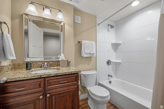955 Delorean Lane Midvale, UT 84047 - Photo 39 of 47 Bathroom featuring a wood-finish vanity with a granite countertop, undermount sink, and a framed mirror