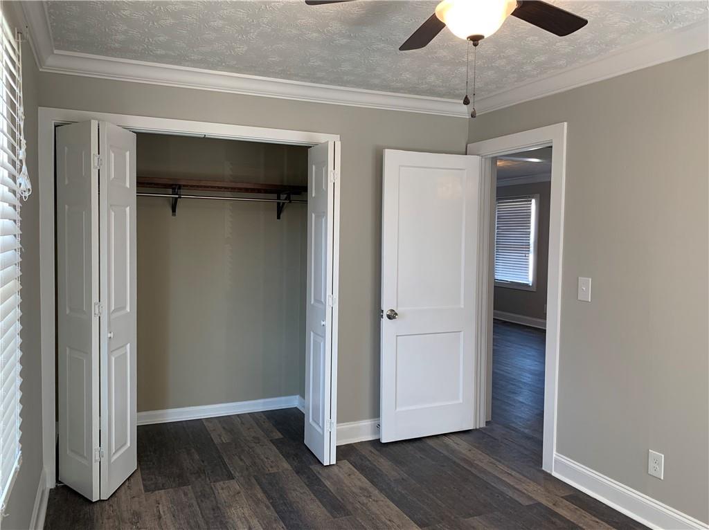1261 Concord Road Southeast Smyrna, GA 30080 - Photo 11 of 50 an empty room with wooden floor a ceiling fan and a window