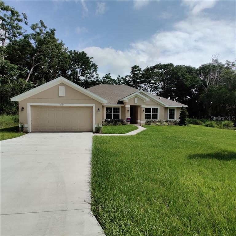a front view of a house with yard and green space