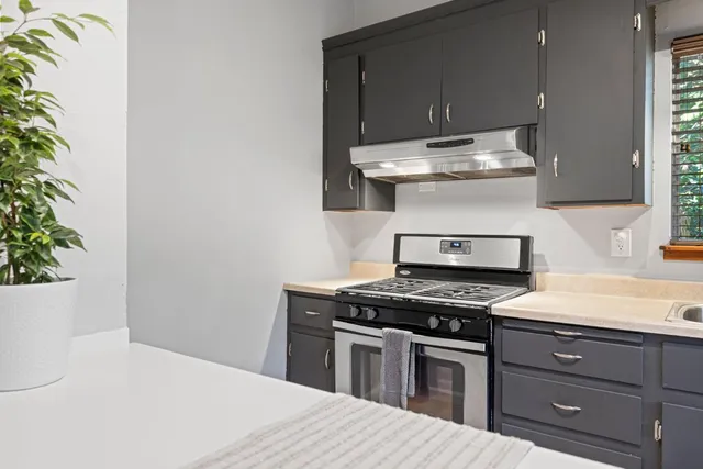 a kitchen with a stove and a white cabinet