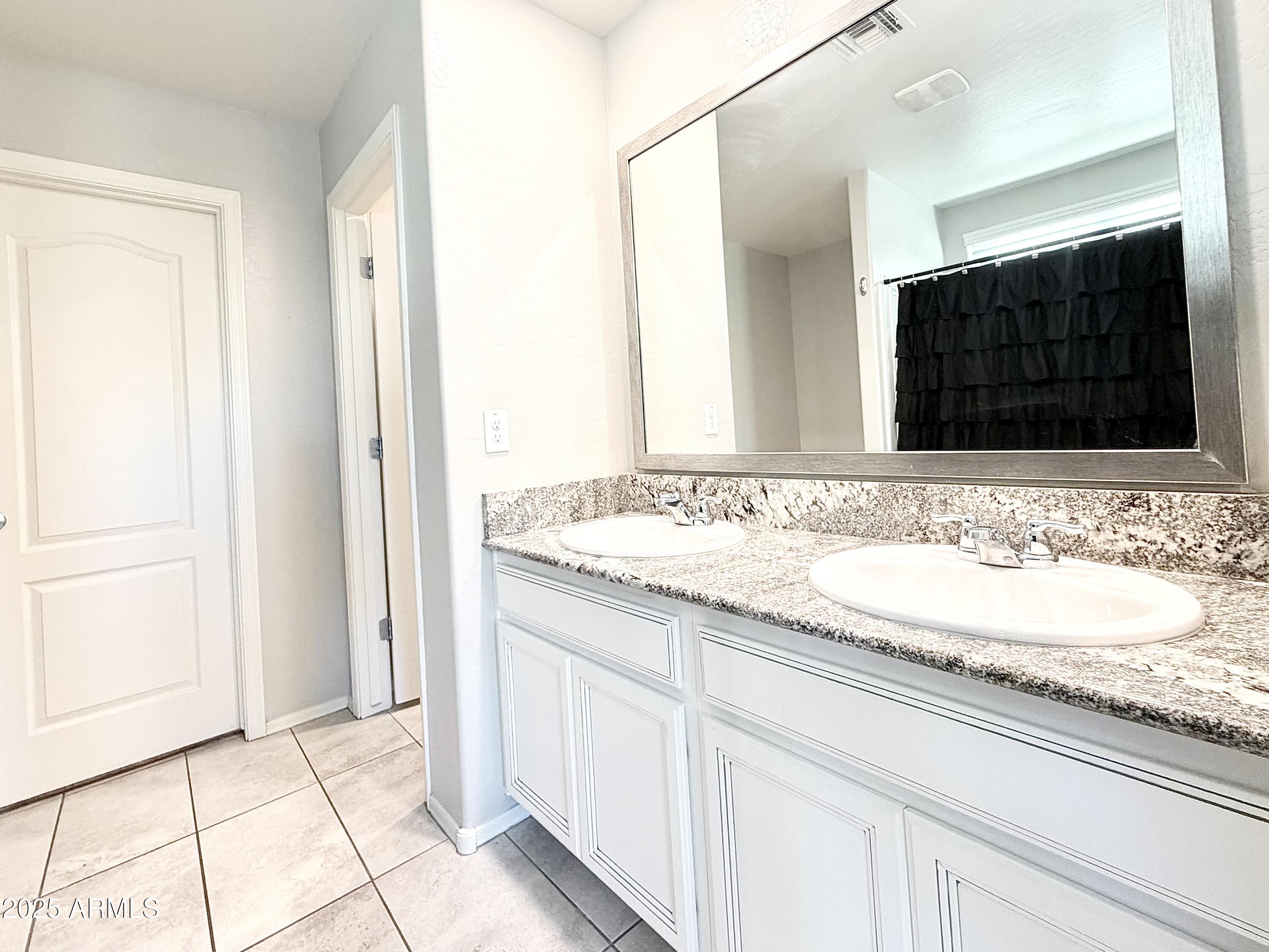 8208 West Sands Road Glendale, AZ 85303 - Photo 13 of 27 a bathroom with a granite countertop sink and a mirror