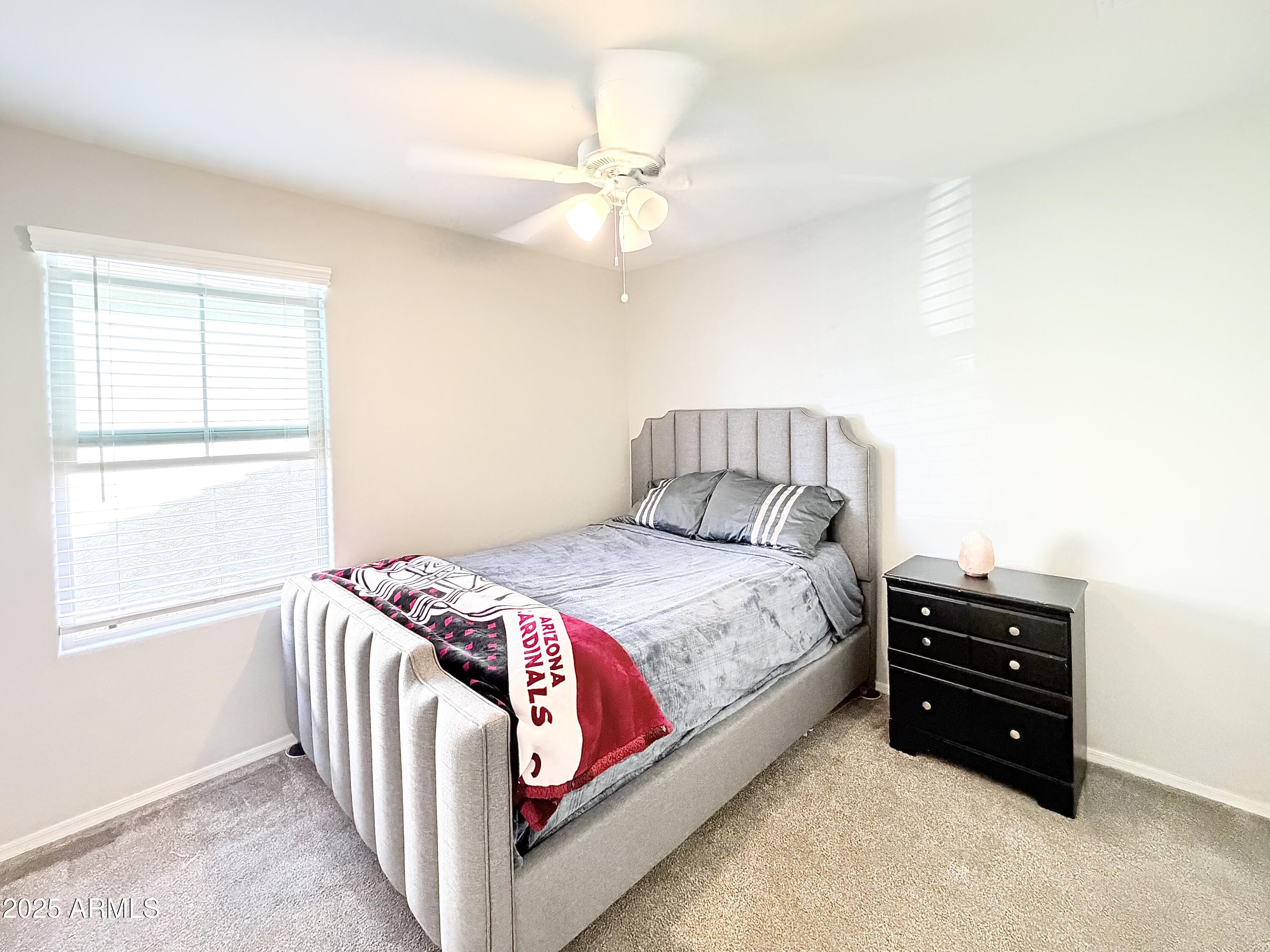 8208 West Sands Road Glendale, AZ 85303 - Photo 15 of 27 a bedroom with a bed and a chandelier