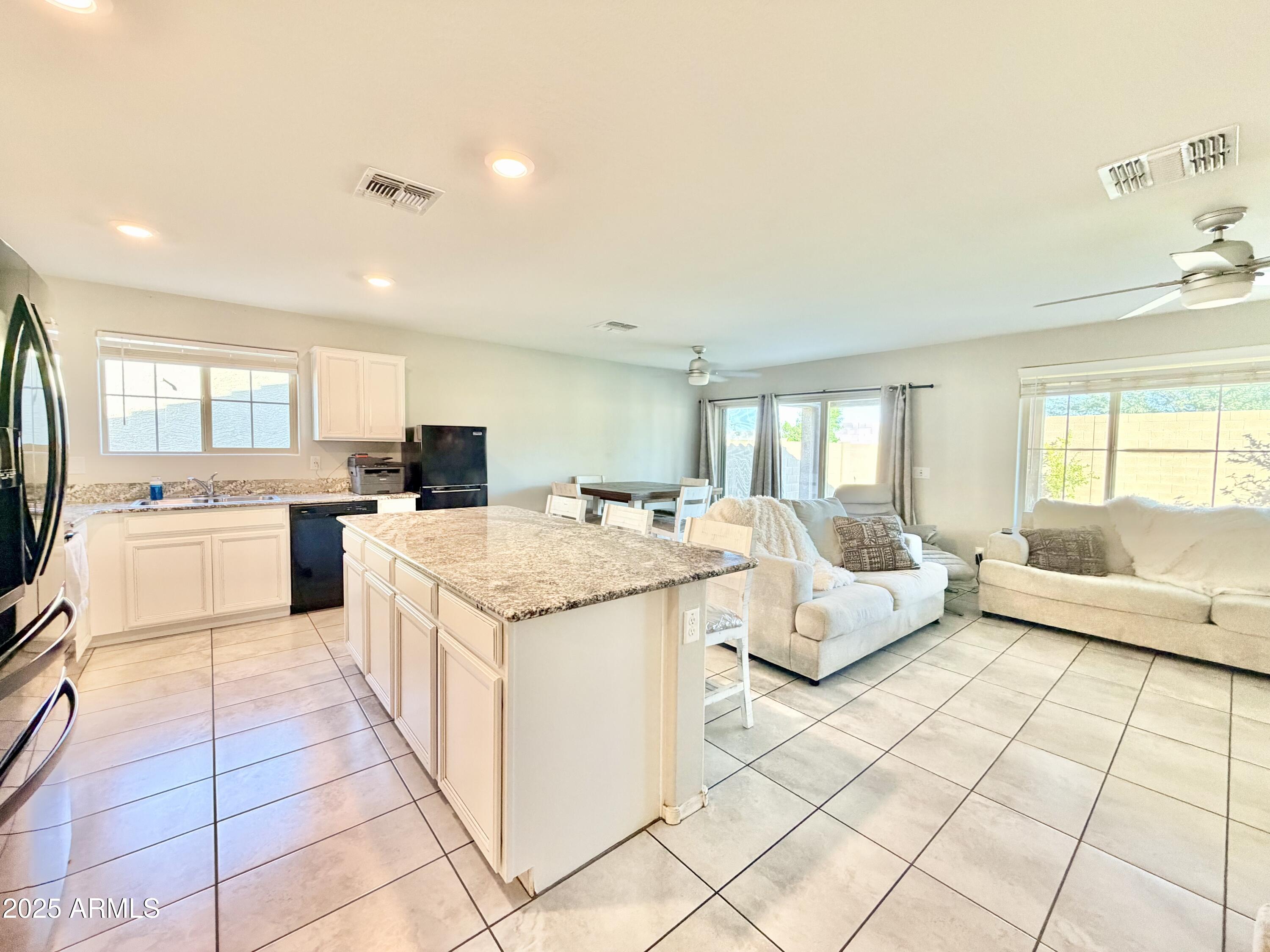 8208 West Sands Road Glendale, AZ 85303 - Photo 4 of 27 a large white kitchen with a stove a sink dishwasher and a refrigerator with white cabinets