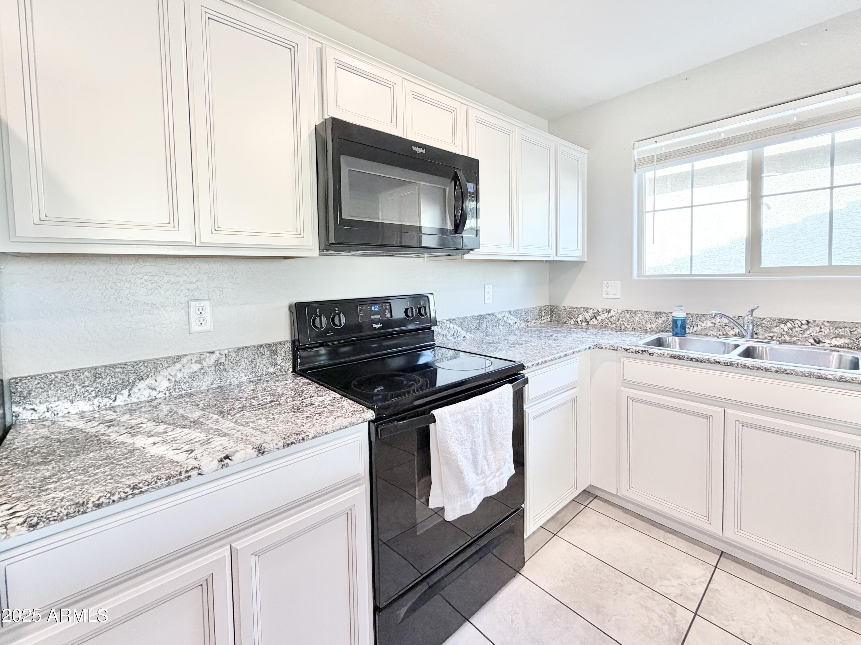 8208 West Sands Road Glendale, AZ 85303 - Photo 9 of 27 a kitchen with granite countertop white cabinets and white appliances