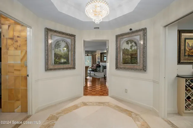 a dining room with furniture a chandelier and wooden floor