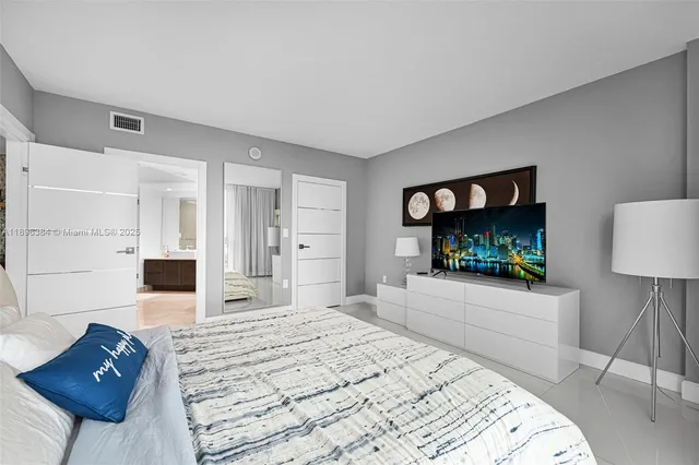 a bedroom with a bed and a flat screen tv