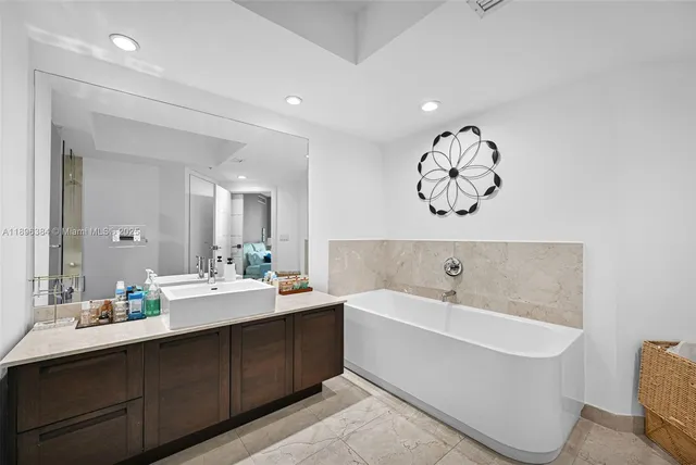 a bathroom with a double vanity sink mirror and bathtub