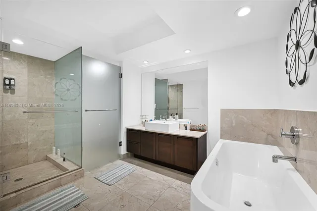 a bathroom with a tub sink and mirror