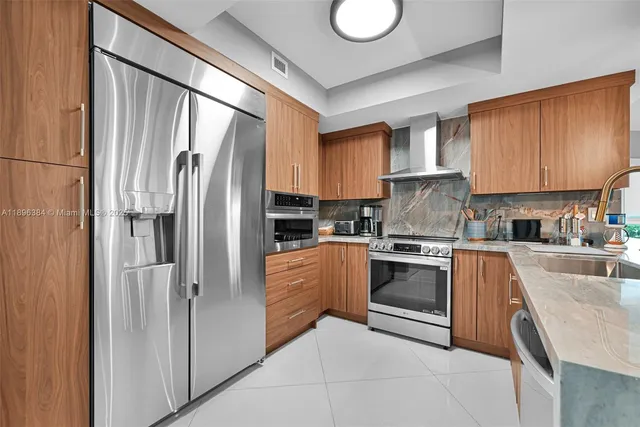 a kitchen with stainless steel appliances granite countertop a refrigerator sink and stove