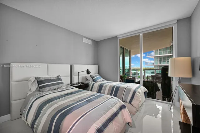 a bedroom with two beds and large window