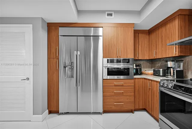 a kitchen with stainless steel appliances granite countertop a refrigerator and a stove