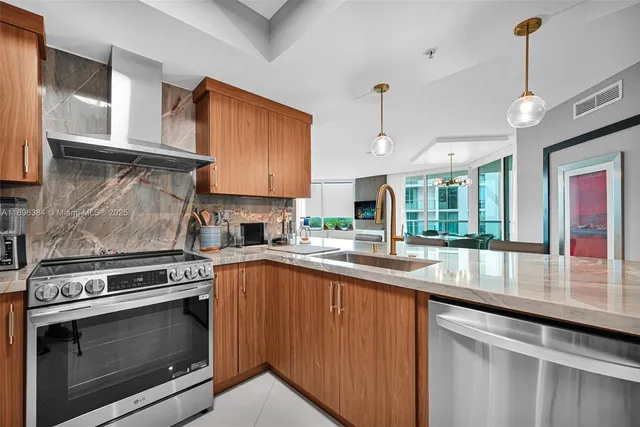 a kitchen with stainless steel appliances granite countertop a stove a sink and a microwave