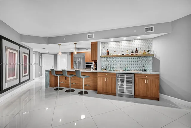 a open kitchen with granite countertop a sink and chairs