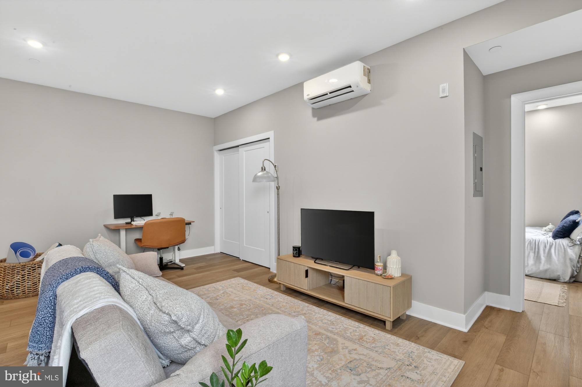 6712 Ridge Avenue, Unit 203 Philadelphia, PA 19128 - Photo 5 of 16 a bedroom with furniture and a flat screen tv