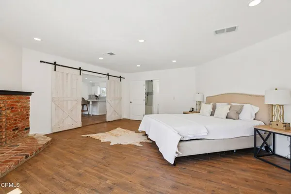 a spacious bedroom with a bed and a refrigerator