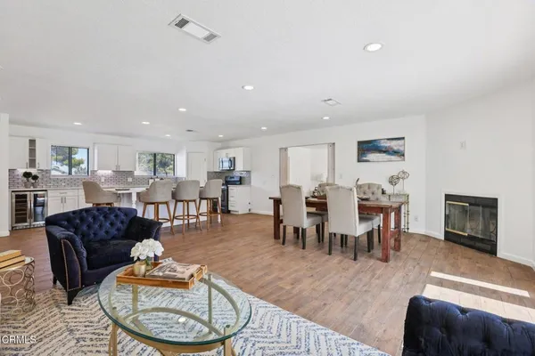 a living room with furniture a dining table and a fireplace