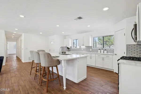 a kitchen with counter space dining table and wooden floor