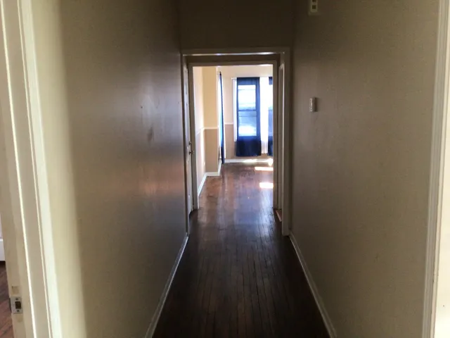 a view of a hallway with wooden floor