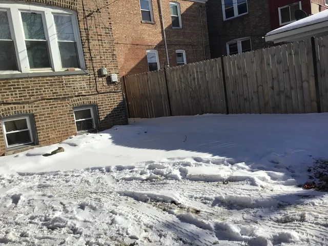 a view of a backyard of a house with wooden fence