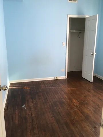 an empty room with wooden floor and closet