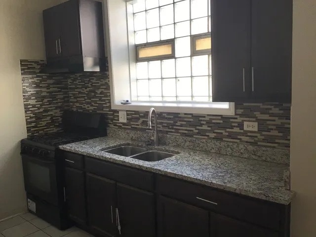 a kitchen with granite countertop a sink and a window
