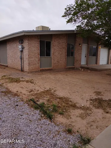 a backyard of a house with large trees and a wooden fence