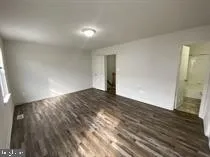a view of an empty room with closet and a window