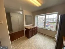 a bathroom with a tub a sink and a large window